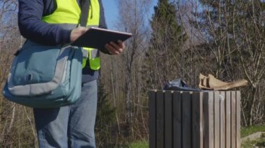 Kadın çevre görevlisi park kirliliğini kontrol ediyor
