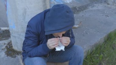 Bağımlı kadın elinde küçük bir paket beyaz toz tutuyor.