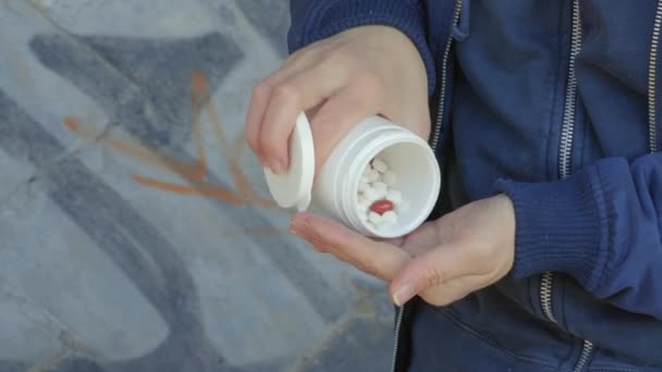 中毒の女性は彼女の手に錠剤を注ぐ — ストック動画