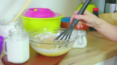 Kadın krep için hamuru karıştırıyor.