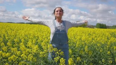Mutlu kadın kolza tohumu tarlasında dinleniyor