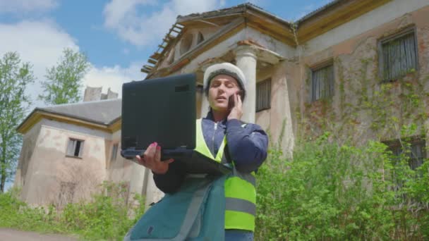 Жінка Будівельник Використовує Ноутбук Смартфон Біля Старої Будівлі — стокове відео