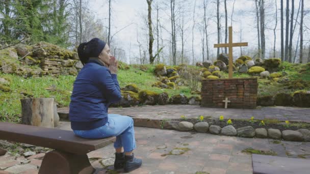 Γυναίκα Προσεύχεται Και Κάθεται Στον Πάγκο Ένα Υπαίθριο Παρεκκλήσι — Αρχείο Βίντεο