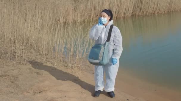 Женщина Исследователь Биологии Использующая Телефон Возле Загрязненного Озера — стоковое видео