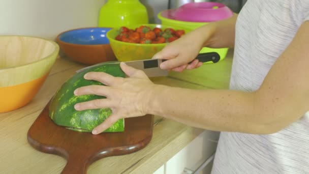 Γυναίκα Κόβει Καρπούζι Ένα Μαχαίρι Δύο Μέρη Στην Κουζίνα — Αρχείο Βίντεο