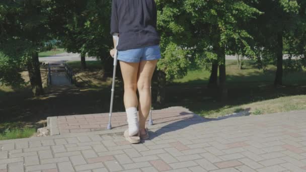 Gehandicapte Vrouw Met Krukken Pad — Stockvideo