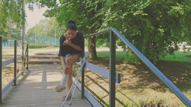 歩行者用橋の上で足が痛い障害のある女性 — ストック動画