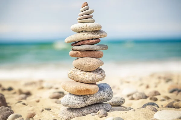 Balanced stones stacked in pile near sea — Stock Photo, Image