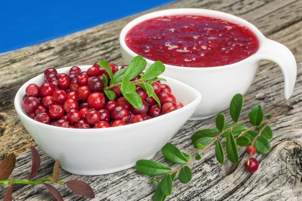 Verse veenbessen in kom met cranberry jam in de buurt van — Stockfoto
