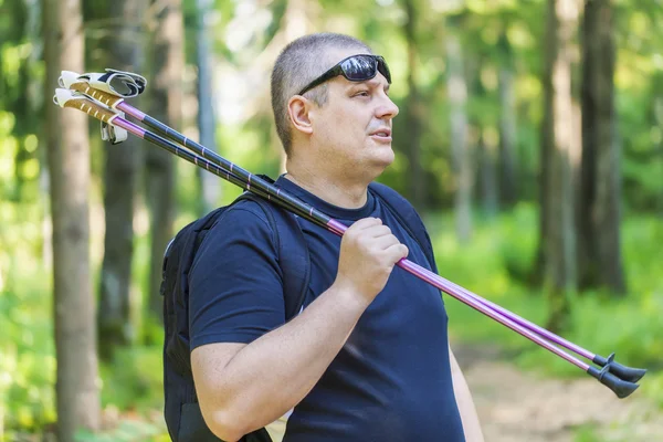 Mann mit Gehstöcken auf Waldweg unterwegs — Stockfoto