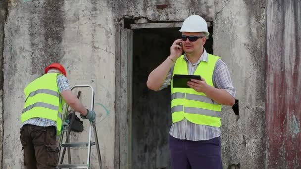 Bauarbeiter nahe eingestürztem Gebäude — Stockvideo