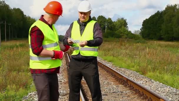 Trabajadores ferroviarios con cuerda cerca del ferrocarril — Vídeos de Stock