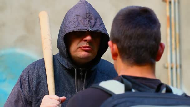 Homme avec une batte de baseball parlant avec un adolescent — Video