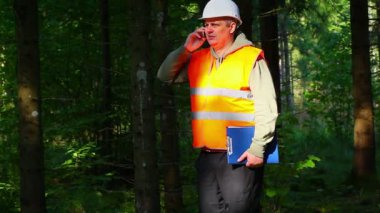 Ormanda klasörlü ve cep telefonlu oduncu