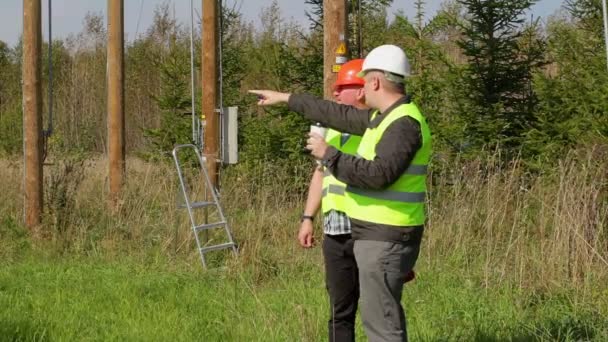 Electricistas hablando al aire libre cerca de puestos eléctricos — Vídeos de Stock