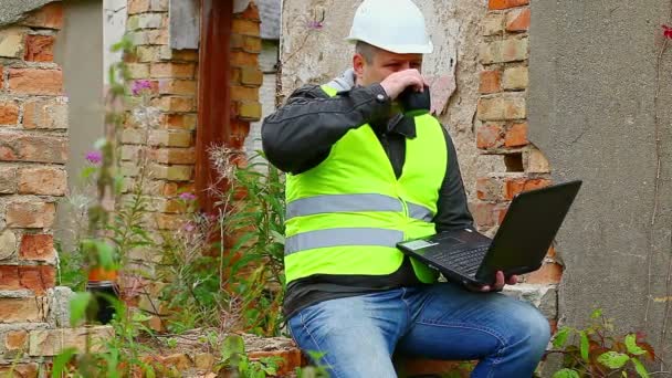 Bauingenieur arbeitet mit PC und trinkt Tee — Stockvideo