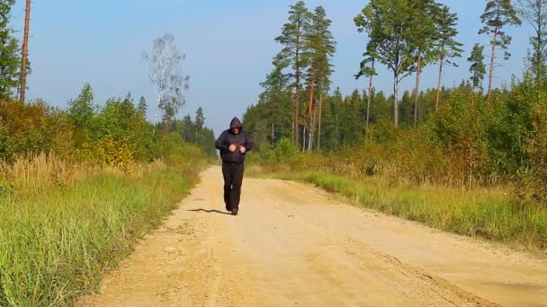 Hombre corriendo por el sendero del bosque — Vídeo de stock