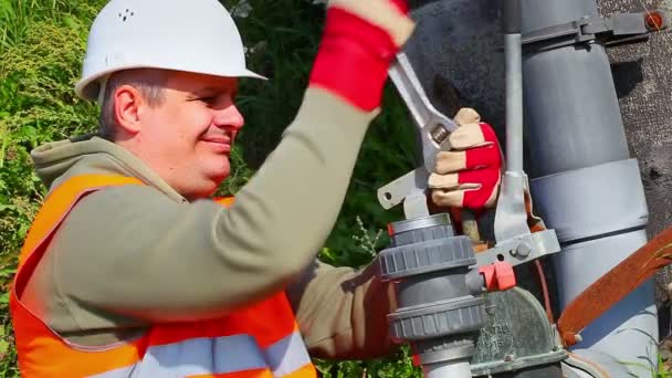 Trabajador con tubo de fijación de llave ajustable al aire libre — Vídeo de stock