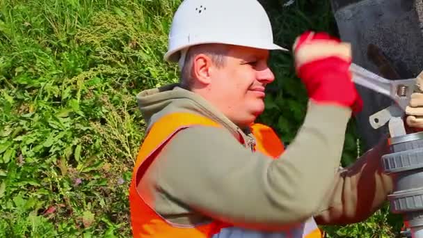 Trabajador con tubo de fijación de llave ajustable al aire libre — Vídeos de Stock