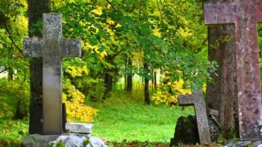 Eski taş mezar üzerinde sonbaharda haçlar.