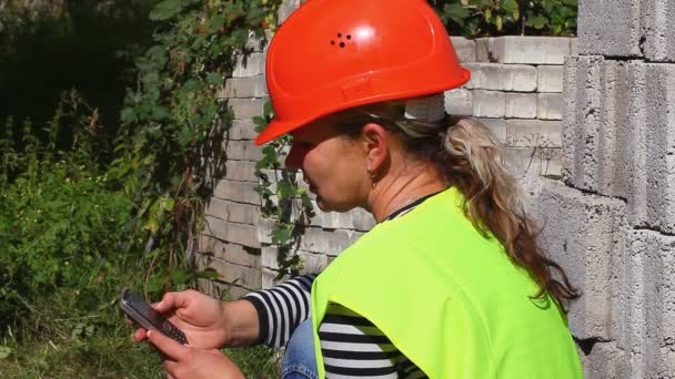 Женщина-строитель с мобильным телефоном — стоковое видео