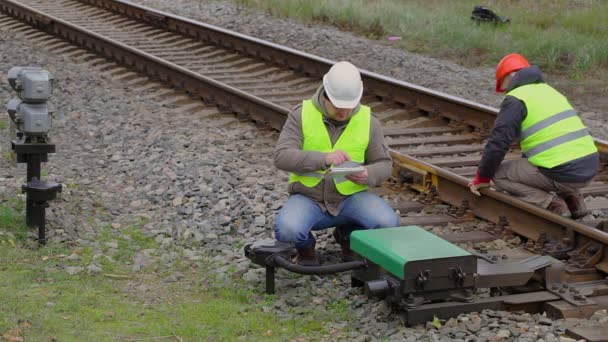 Dos empleados ferroviarios realizando mantenimiento — Vídeo de stock