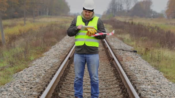 Spoorweg ingenieur met tablet Pc en waarschuwing tape — Stockvideo