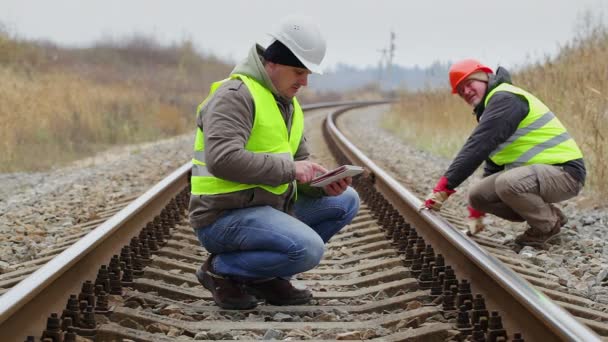 Μηχανικός που εργάζονται με το Pc ταμπλετών επί της σιδηροδρομικής γραμμής — Αρχείο Βίντεο