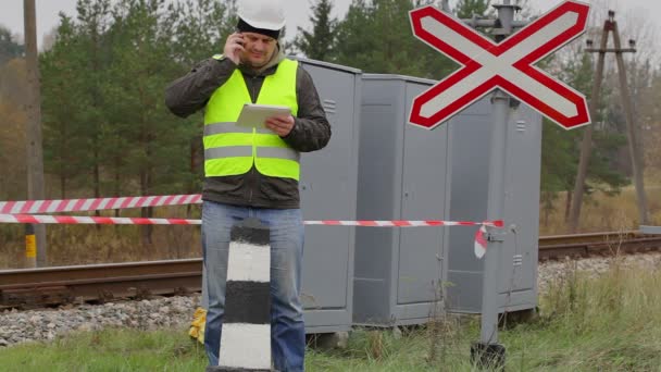 Järnväg ingenjör talar i mobiltelefon innan varning tejp — Stockvideo