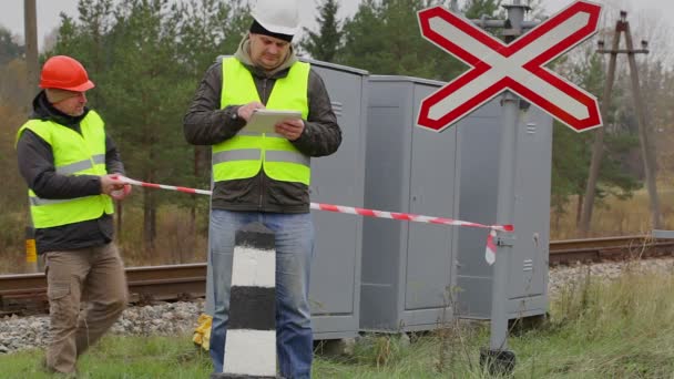 Ingeniero ferroviario con tableta PC antes de cinta de advertencia — Vídeo de stock