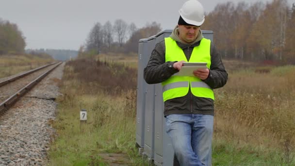 Spoorweg ingenieur werken met tablet Pc in de buurt van railway — Stockvideo