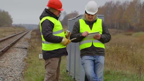 Železniční inženýr mluvit s pracovníkem s štětce a barvy — Stock video