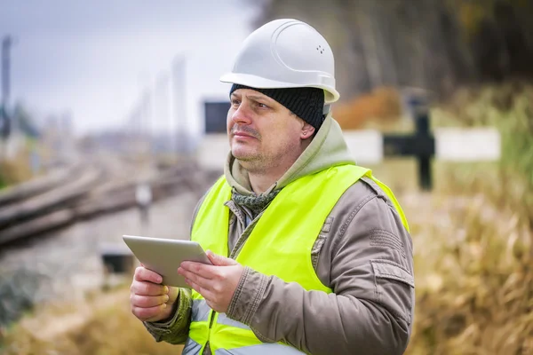 Engenheiro ferroviário perto de trilhos trabalhando com tablet PC — Fotografia de Stock