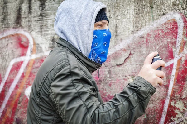 L'uomo con spray a colori può vicino alla vecchia parete — Foto Stock