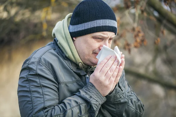 Man met servet in de buurt van neus in de open lucht op de Bank — Stockfoto