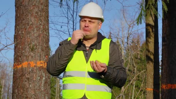Лесной инженер ест чипсы в лесу — стоковое видео