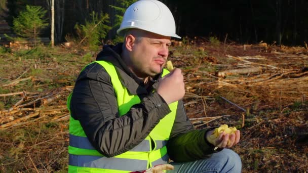 Lumberjack eating potato chips in the forest — Stock Video