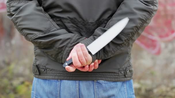 Hombre con cuchillo detrás de la espalda — Vídeo de stock