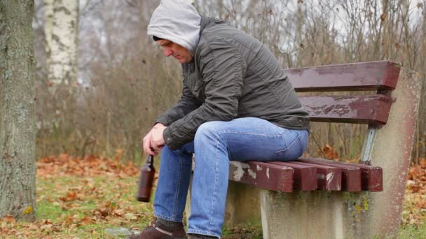 Lonely man with beer bottle in the park — Stock Video