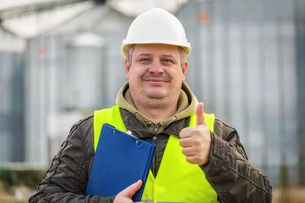 Werknemer met map in de buurt van de fabriek — Stockfoto