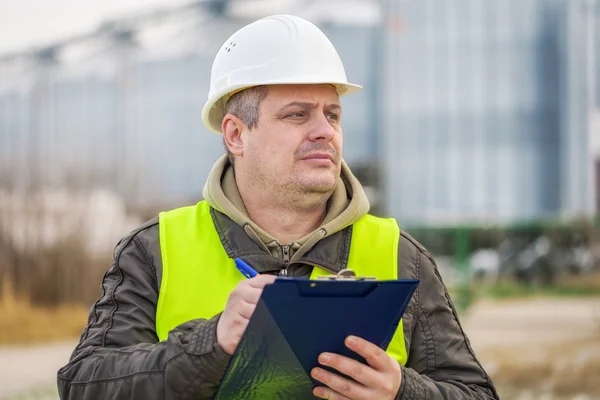 Arbetare med mappen nära fabriken i vinter — Stockfoto