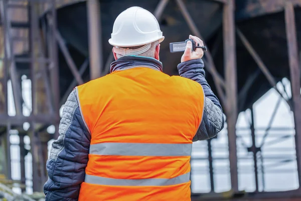 Engineer filmed with camcorder in factory — Stock Photo, Image