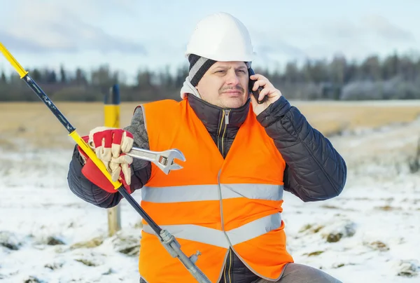 Electrical worker with cell phone near tensioner — Stock Photo, Image