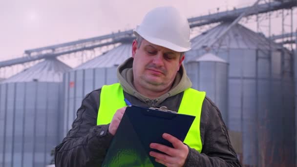 Werknemer met map in de buurt van de fabriek — Stockvideo