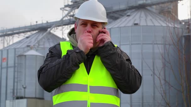 Pracownik z telefonów komórkowych w pobliżu fabryki w zimie — Wideo stockowe