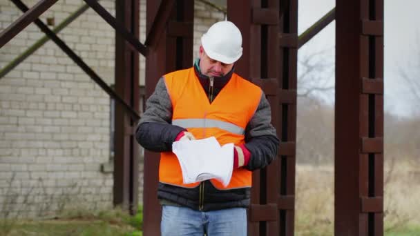 Trabajador con documentos al aire libre en fábrica — Vídeos de Stock