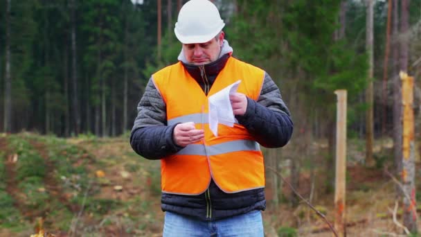 Лесной инженер сжигает важные документы в лесу — стоковое видео