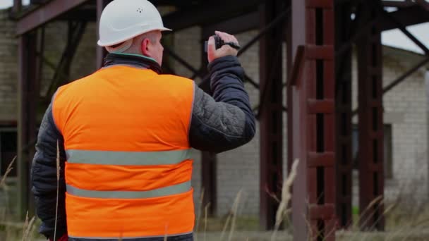 Inspector de edificio filmado con videocámara en fábrica — Vídeos de Stock