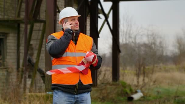 Dělník s výstražné pásky a mobilní telefon — Stock video