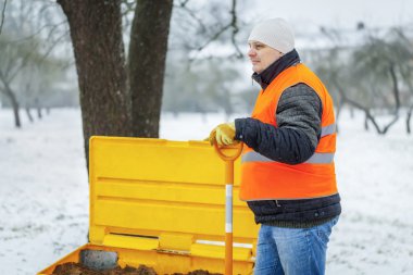 Worker with snow shovel in winter clipart